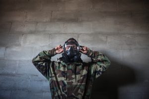 a guy wearing a gas mask wearing army fatigues